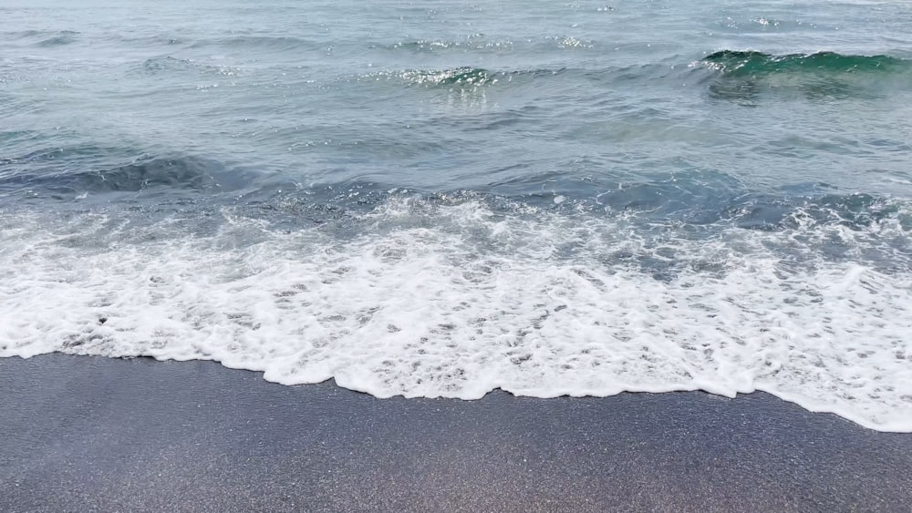 ocean waves crashing on shore during daytime