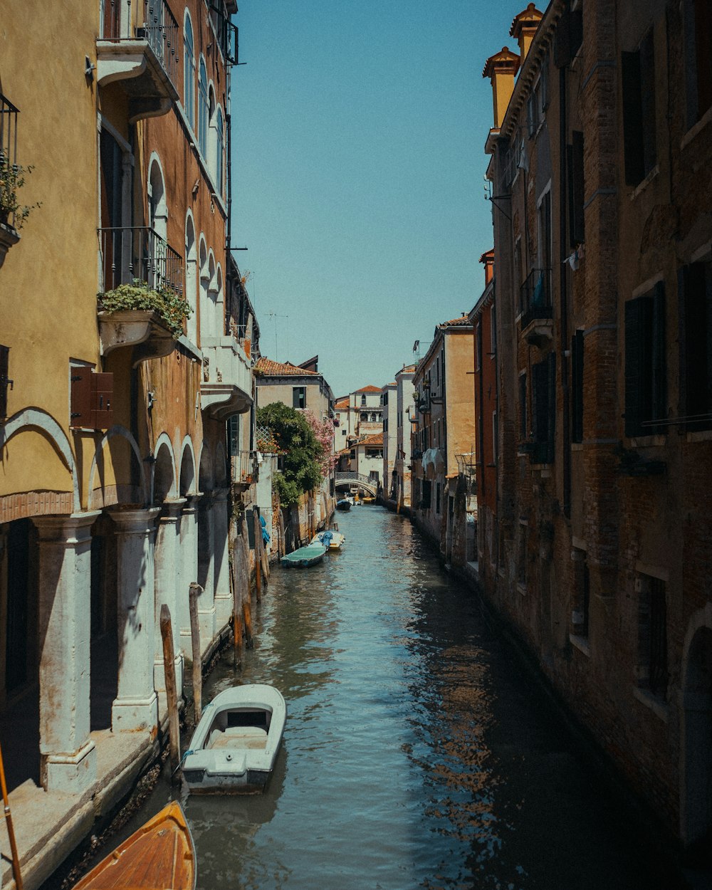 white boat on river between buildings during daytime