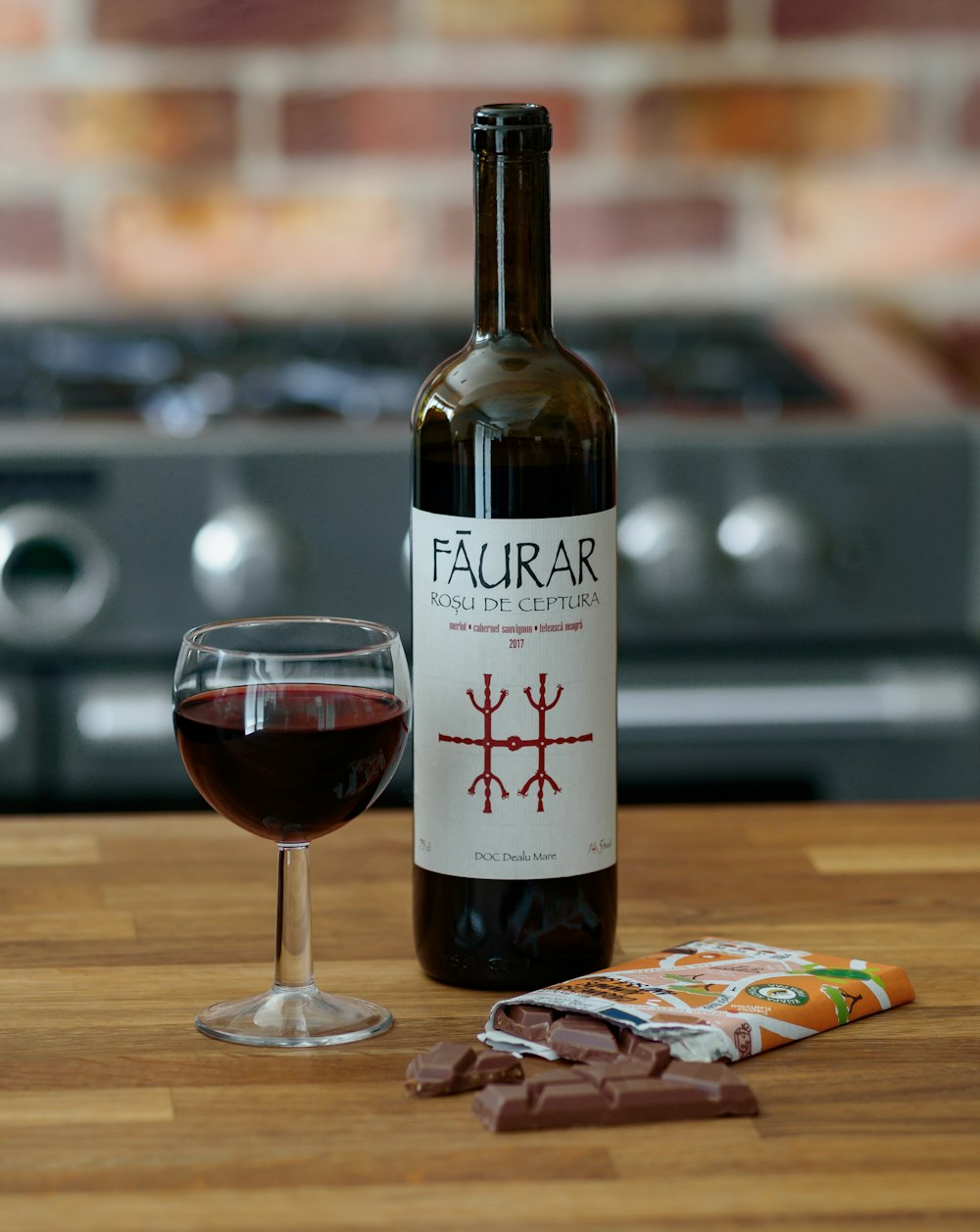 white labeled bottle beside wine glass on brown wooden table