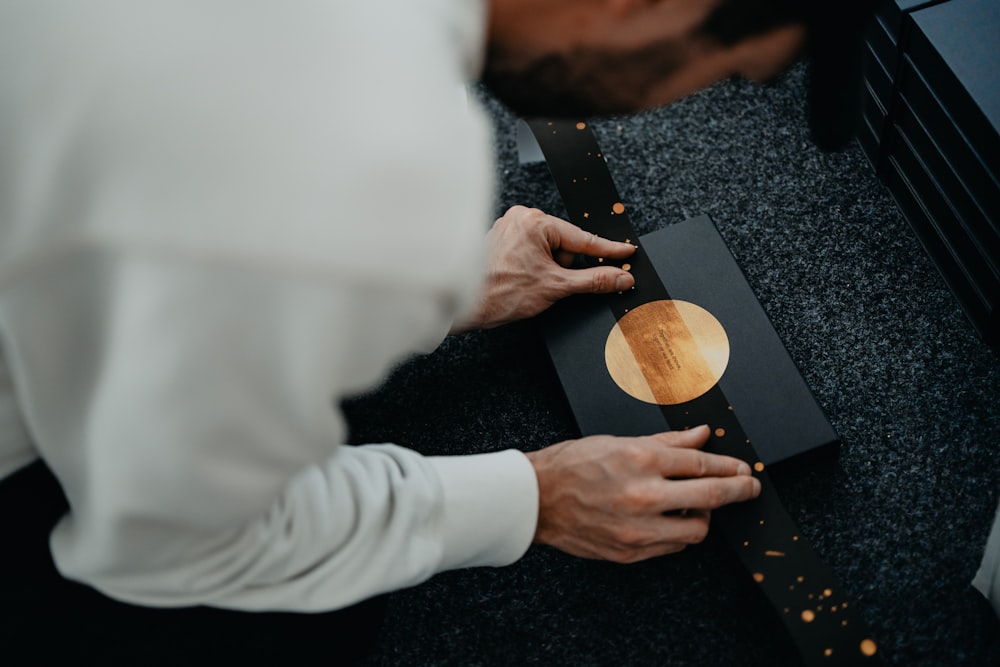 person in white long sleeve shirt holding brown wooden chopping board