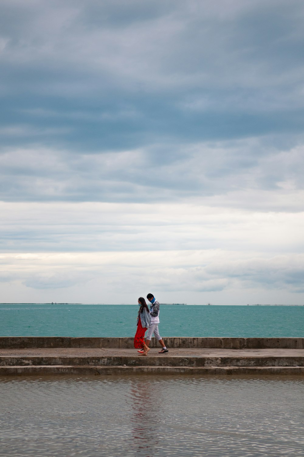 hombre y mujer caminando en la playa durante el día