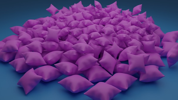 A large pile of purple pillows is spread out on a blue background.