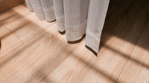 white window curtain on brown wooden floor