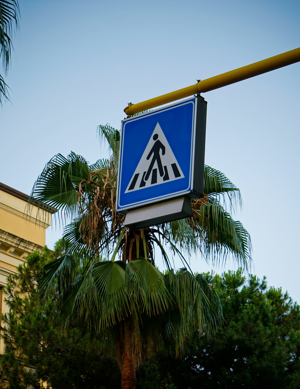 a blue and white street sign hanging from a yellow pole