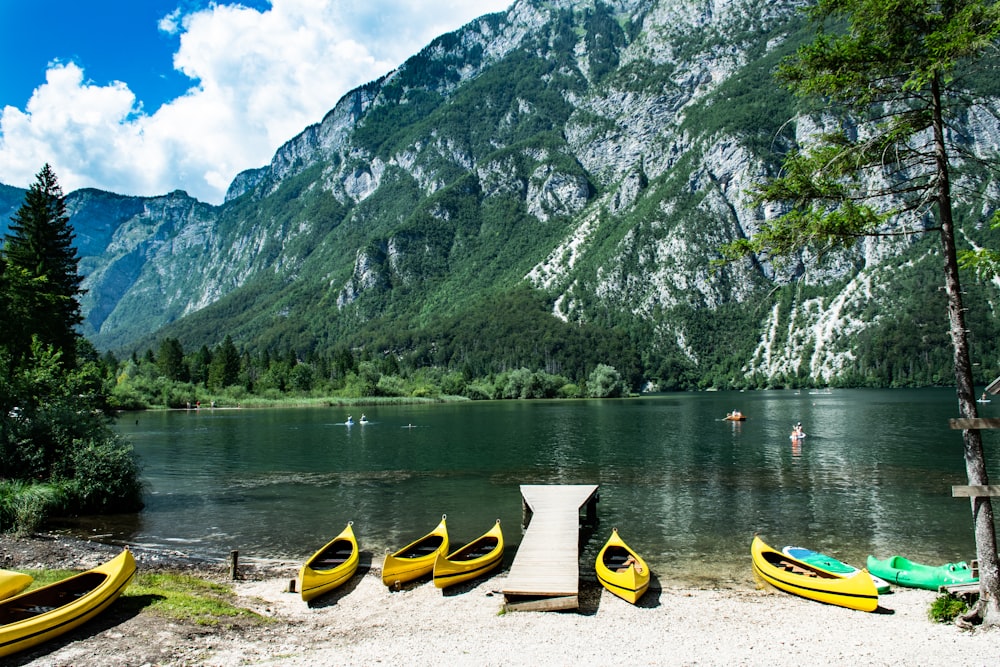 yellow kayak on shore near mountain during daytime