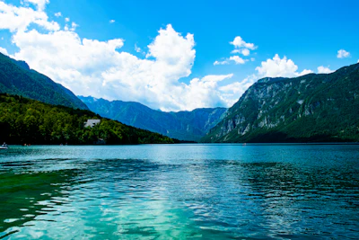 Lake Bohinj, green water between forested slopes and the Julian Alps