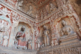 Detailed carvings on a temple wall depicting scenes from monastic life in the Mulasarvastivada tradition.