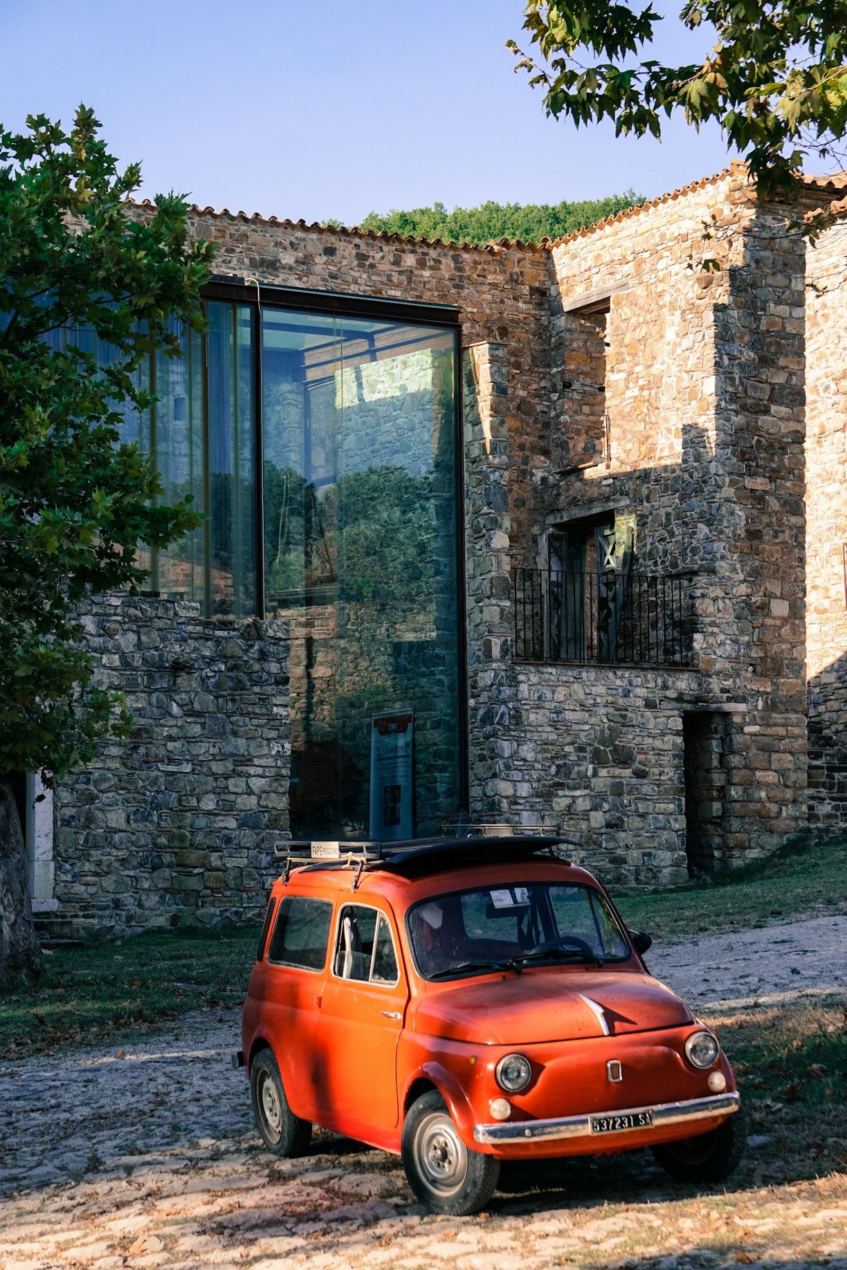 orange car parked beside brown brick building