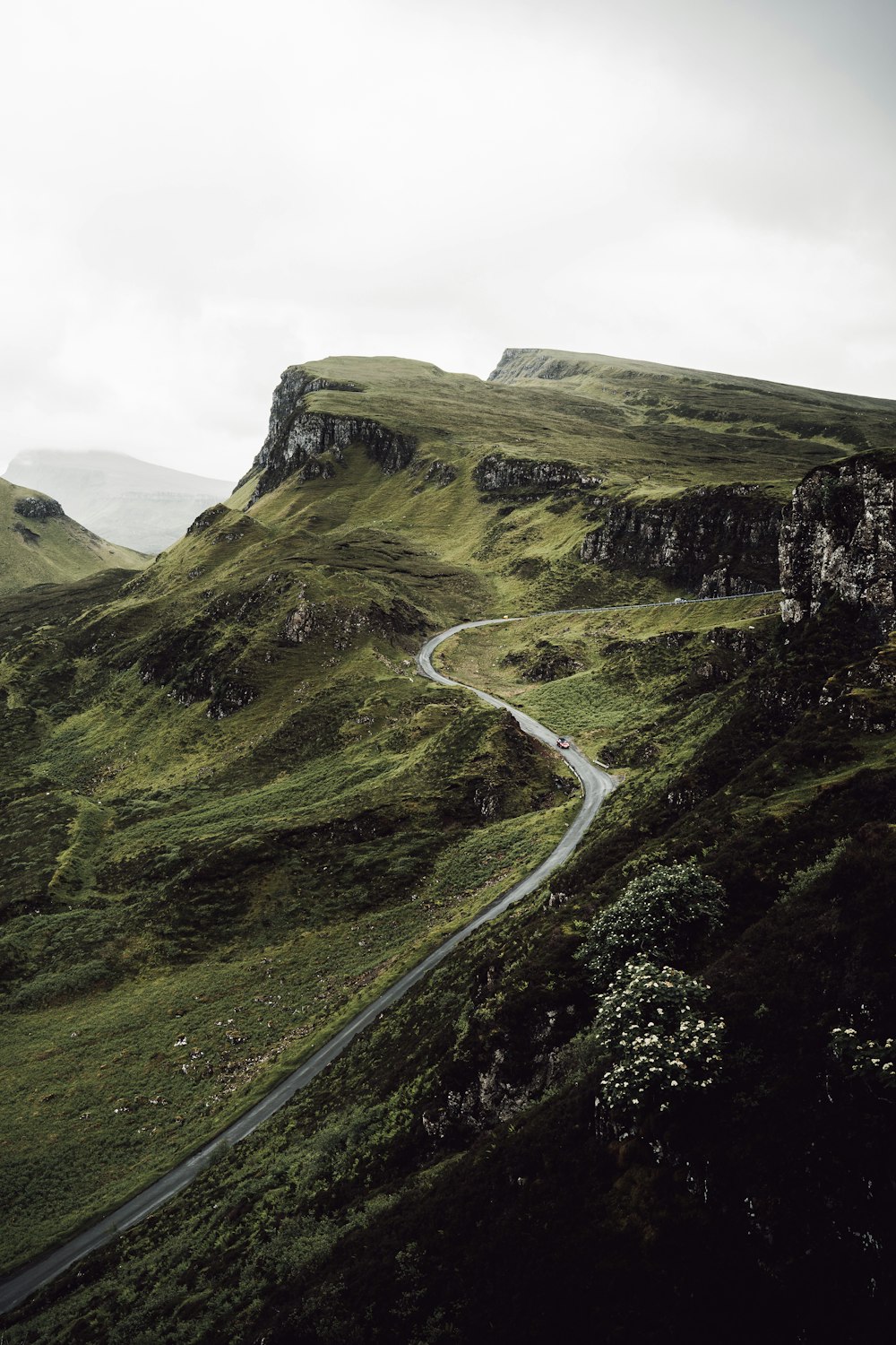 green grass covered mountain under cloudy sky during daytime