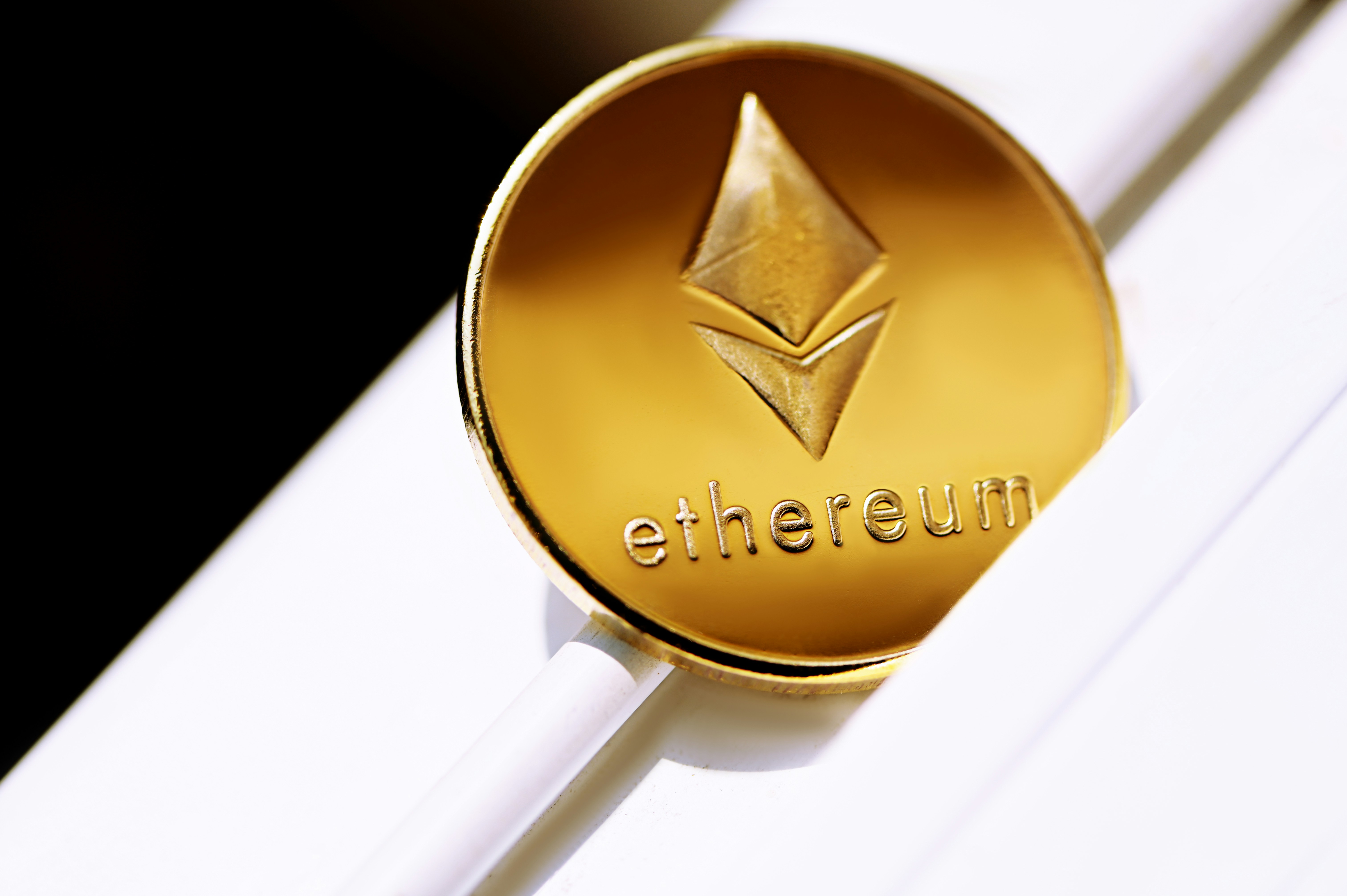 Ethereum coin on top of the white surface