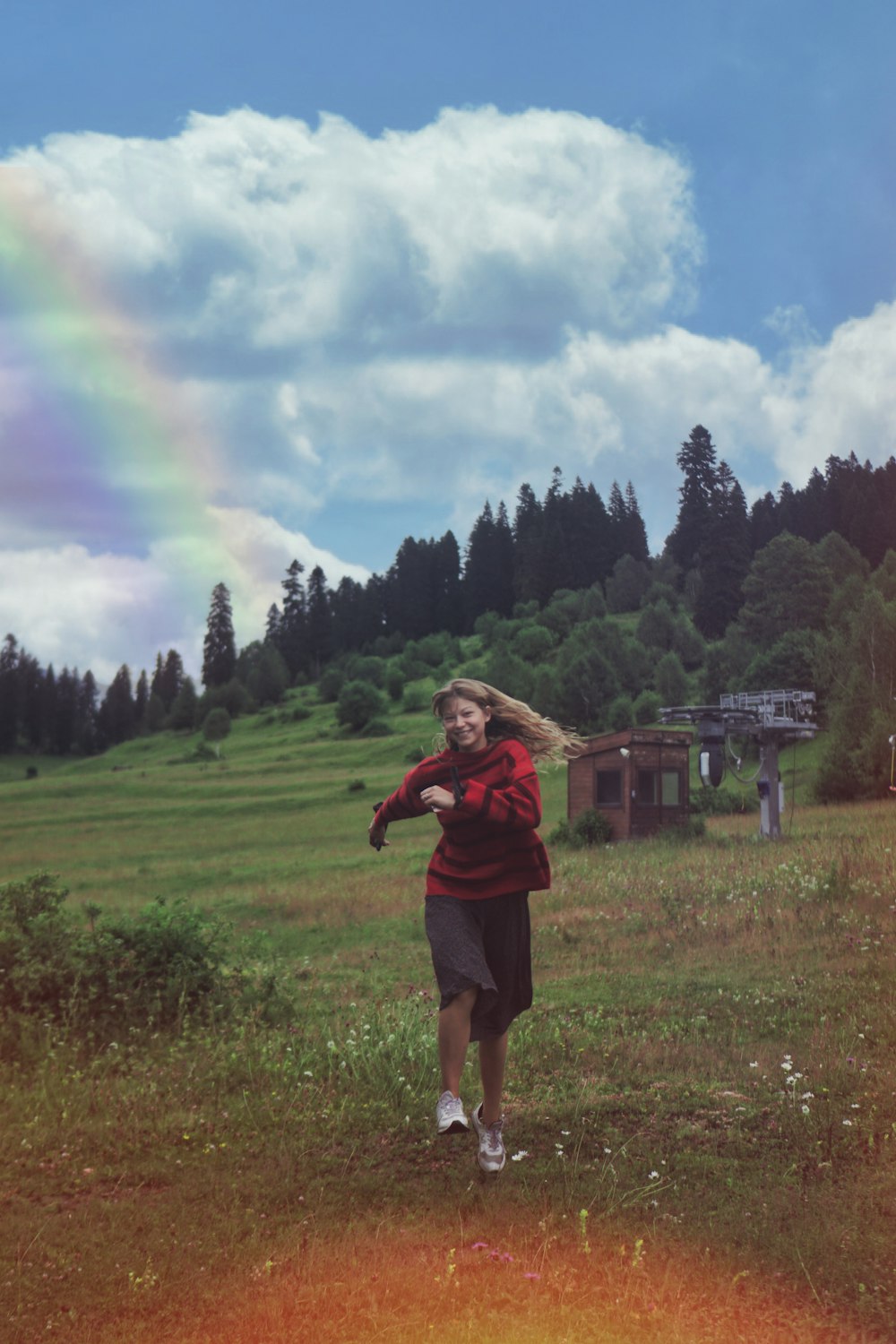 woman in red long sleeve shirt standing on green grass field during daytime