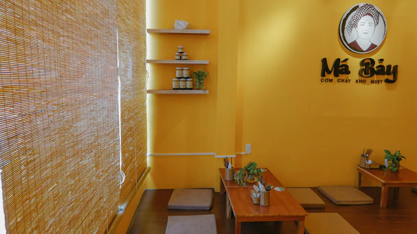 A warm, inviting Indonesian restaurant interior with traditional wooden decor and vibrant plates of food on the table