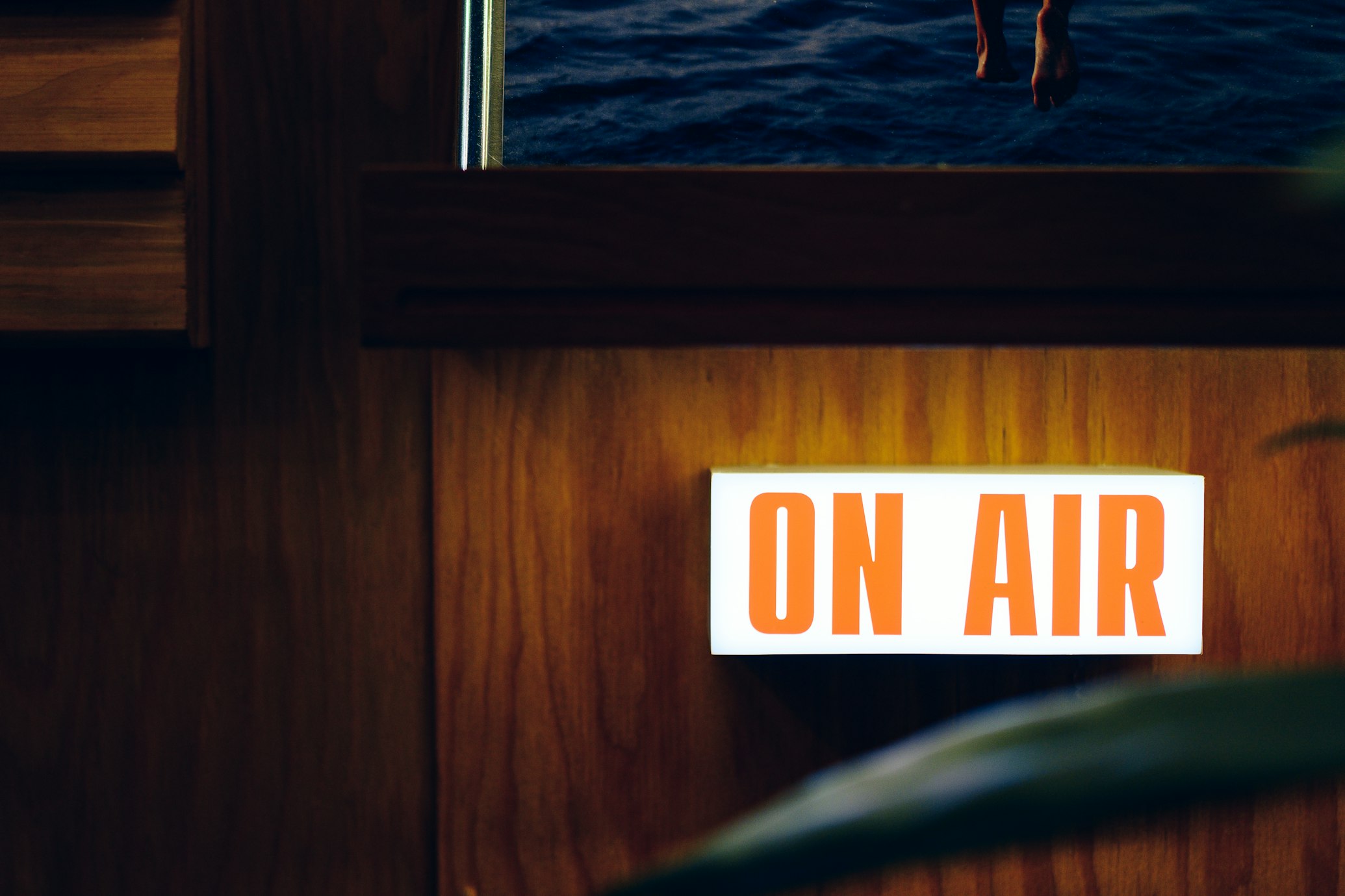 A 'On Air' lit up sign on some wood panelling