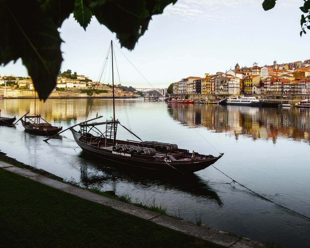 brown boat on river near city buildings during daytime