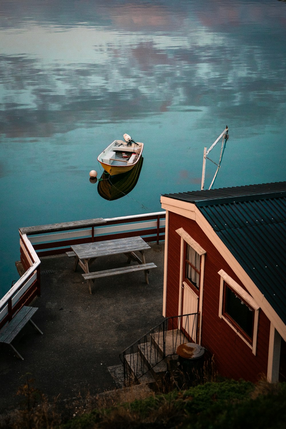 brown and white wooden house beside body of water during daytime