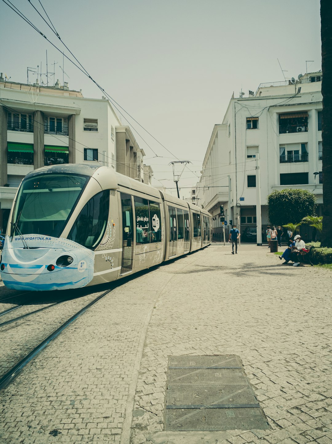 white and blue train on the street during daytime