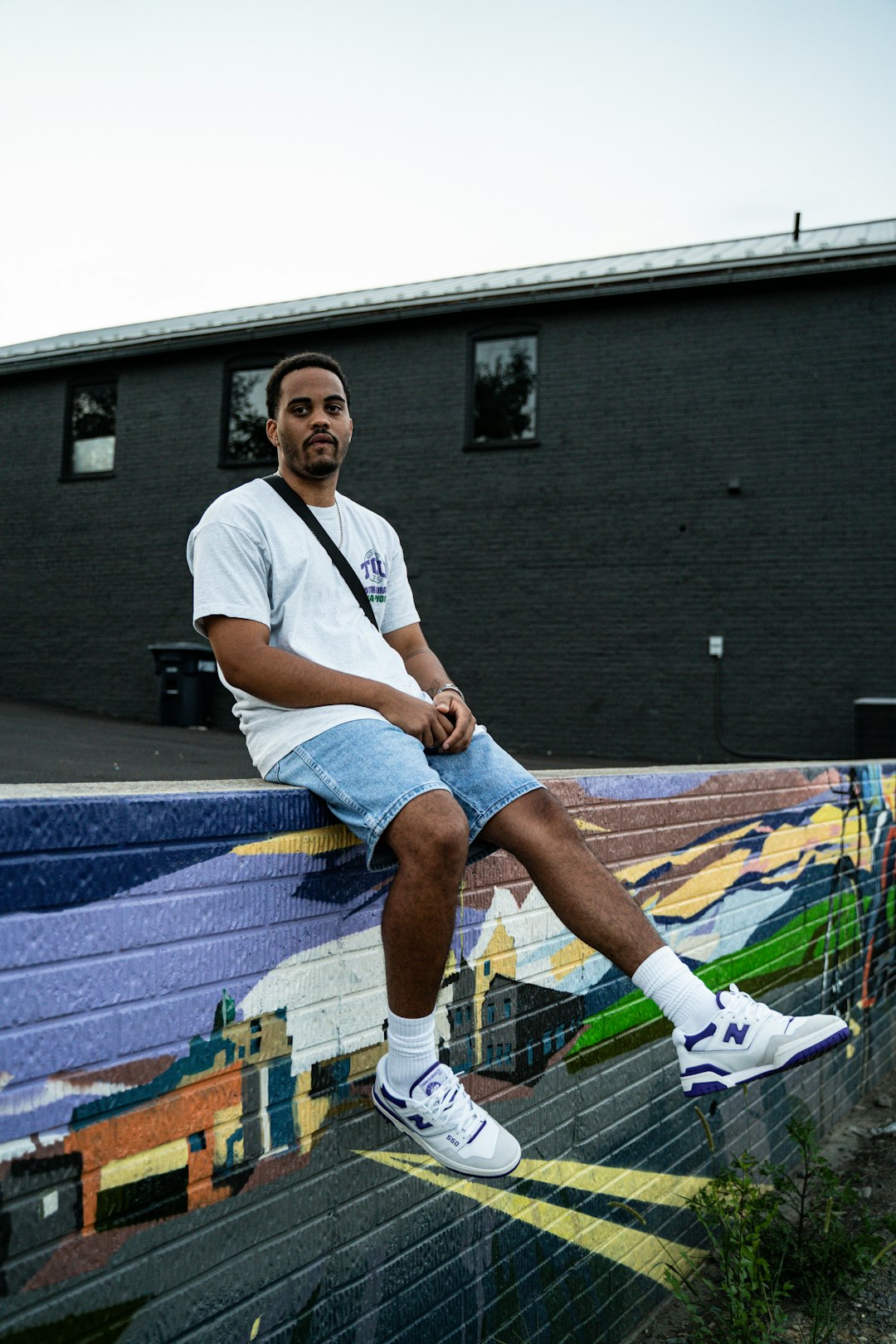 man in white crew neck t-shirt and blue denim shorts sitting on blue and white