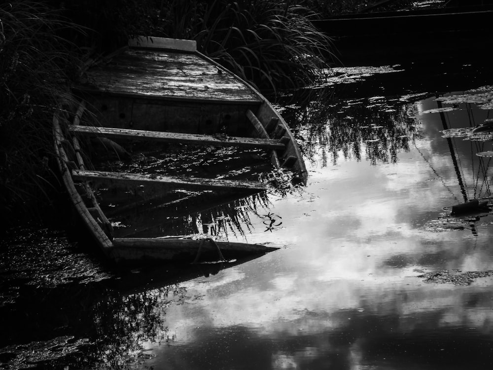 grayscale photo of wooden boat on water