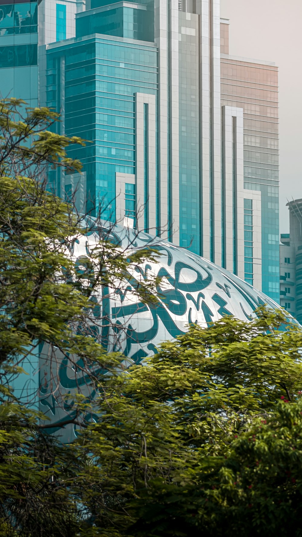 green tree near high rise building during daytime