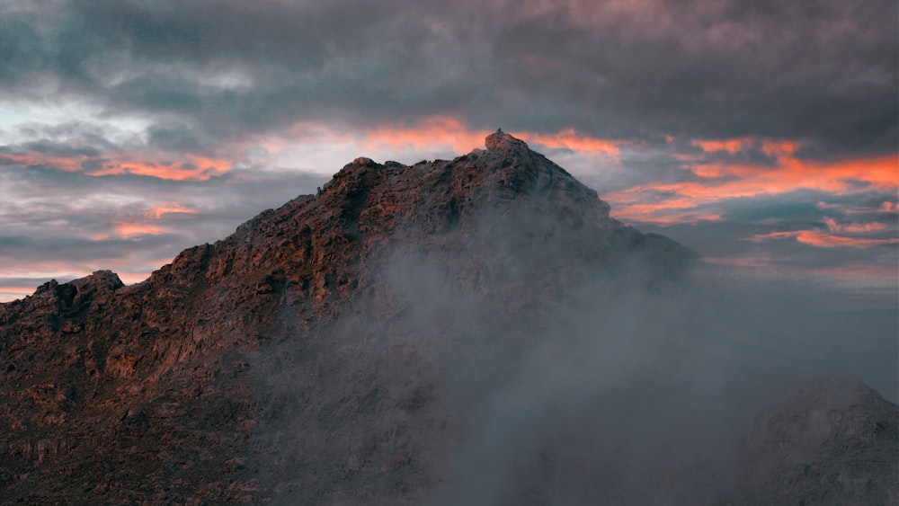 brown mountain under white clouds during daytime