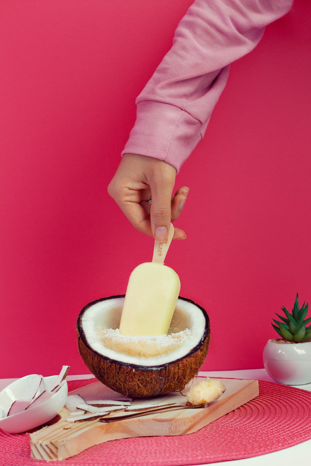 person in pink long sleeve shirt holding white rolling pin