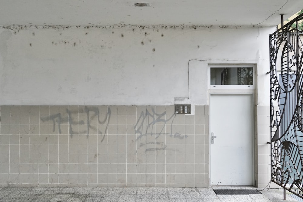 white metal door on white concrete wall