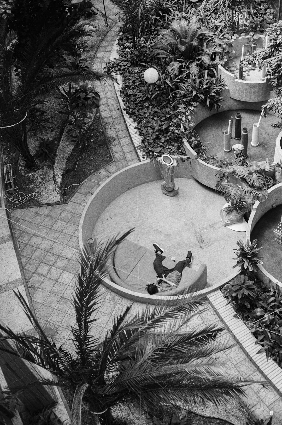 grayscale photo of bird on round fountain