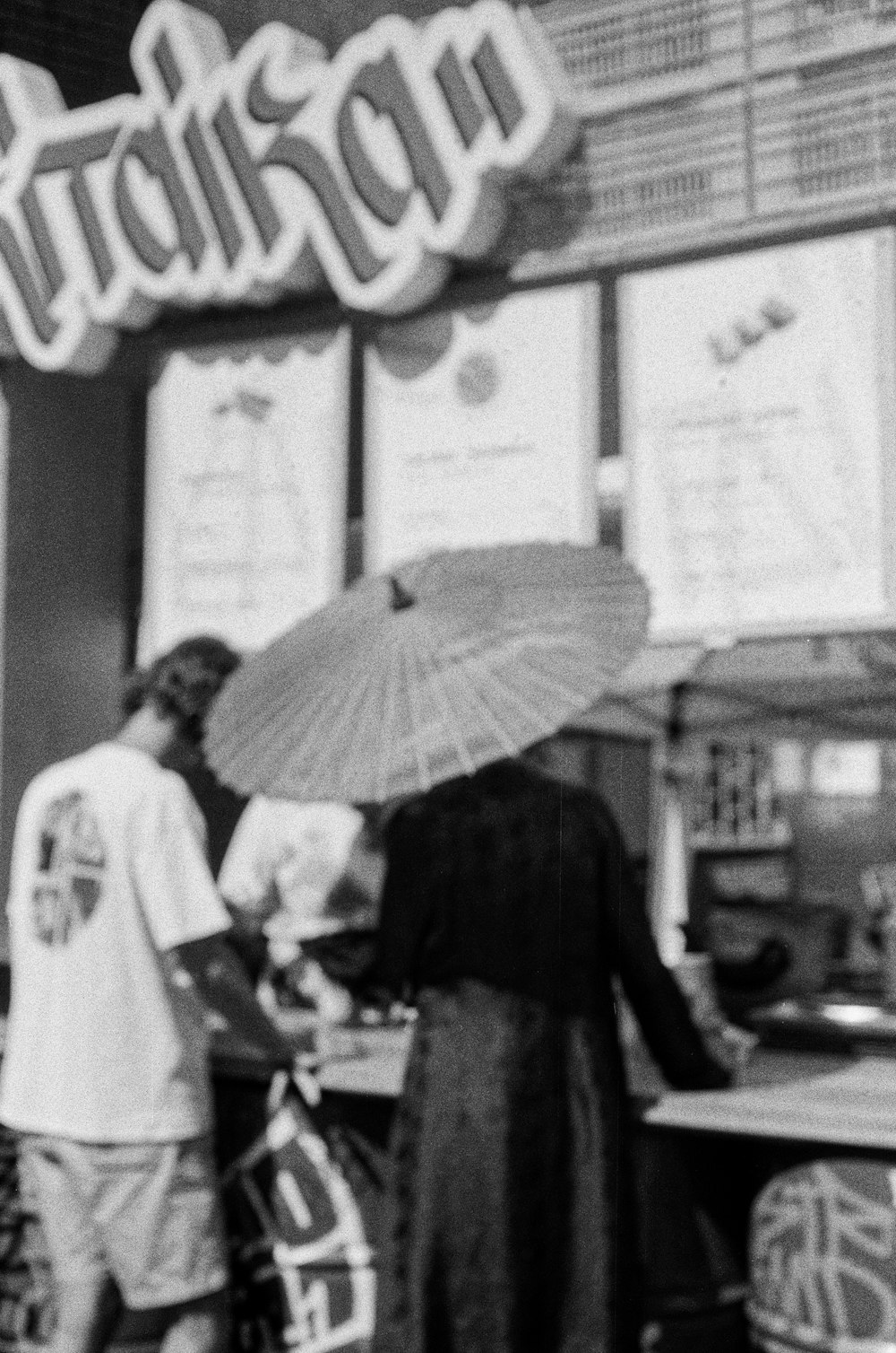 grayscale photo of man and woman holding umbrella