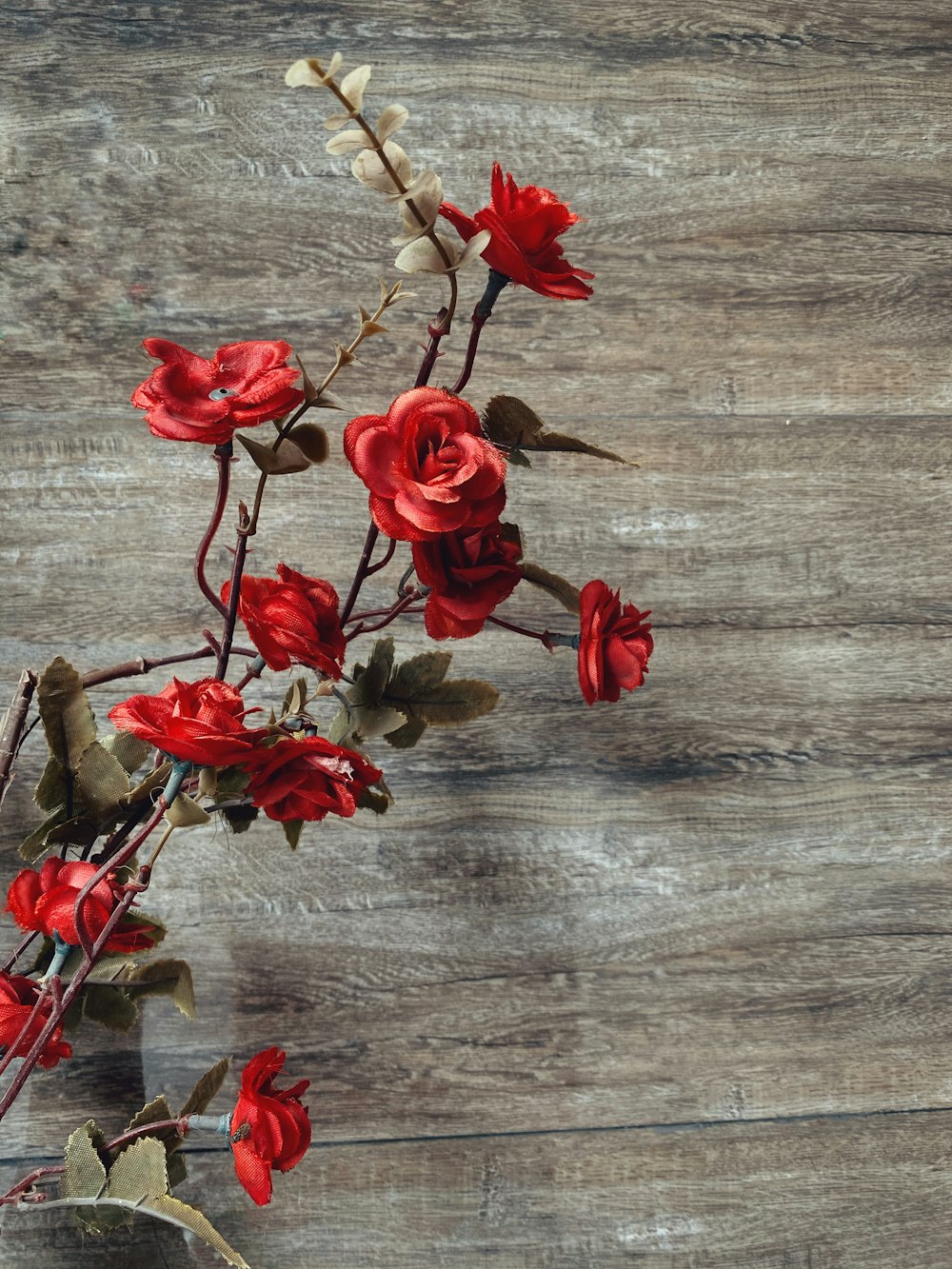 red roses on brown wooden surface