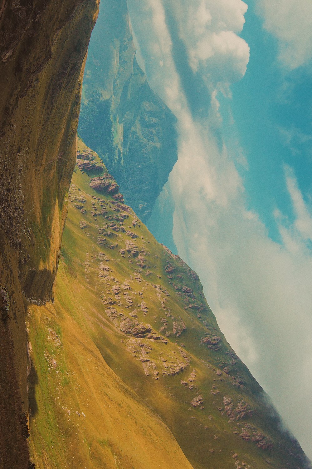 green and brown mountain under white clouds and blue sky during daytime