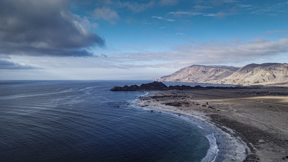 blue sky over sea and brown mountain