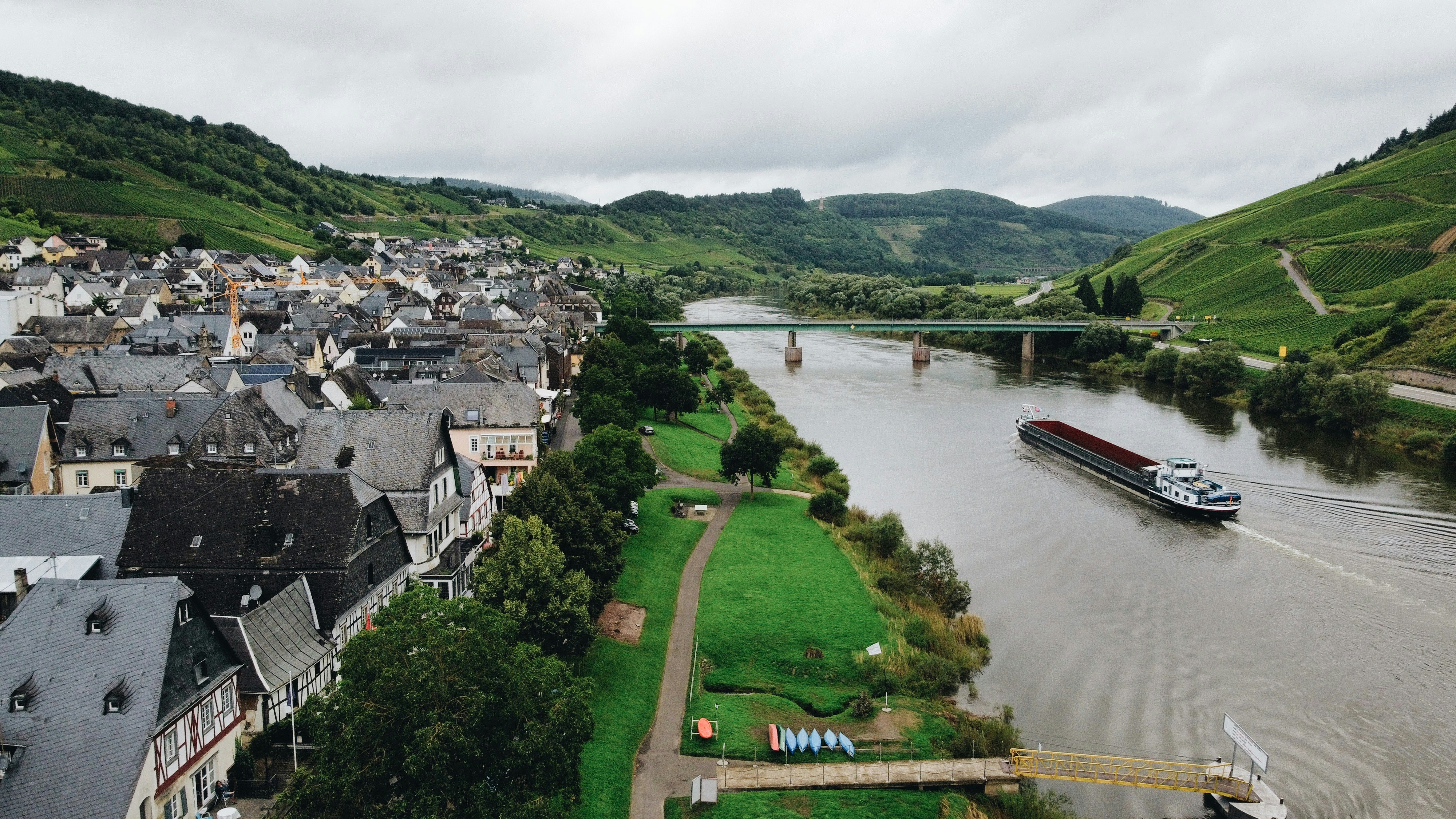 body of water near green grass field and houses during daytime