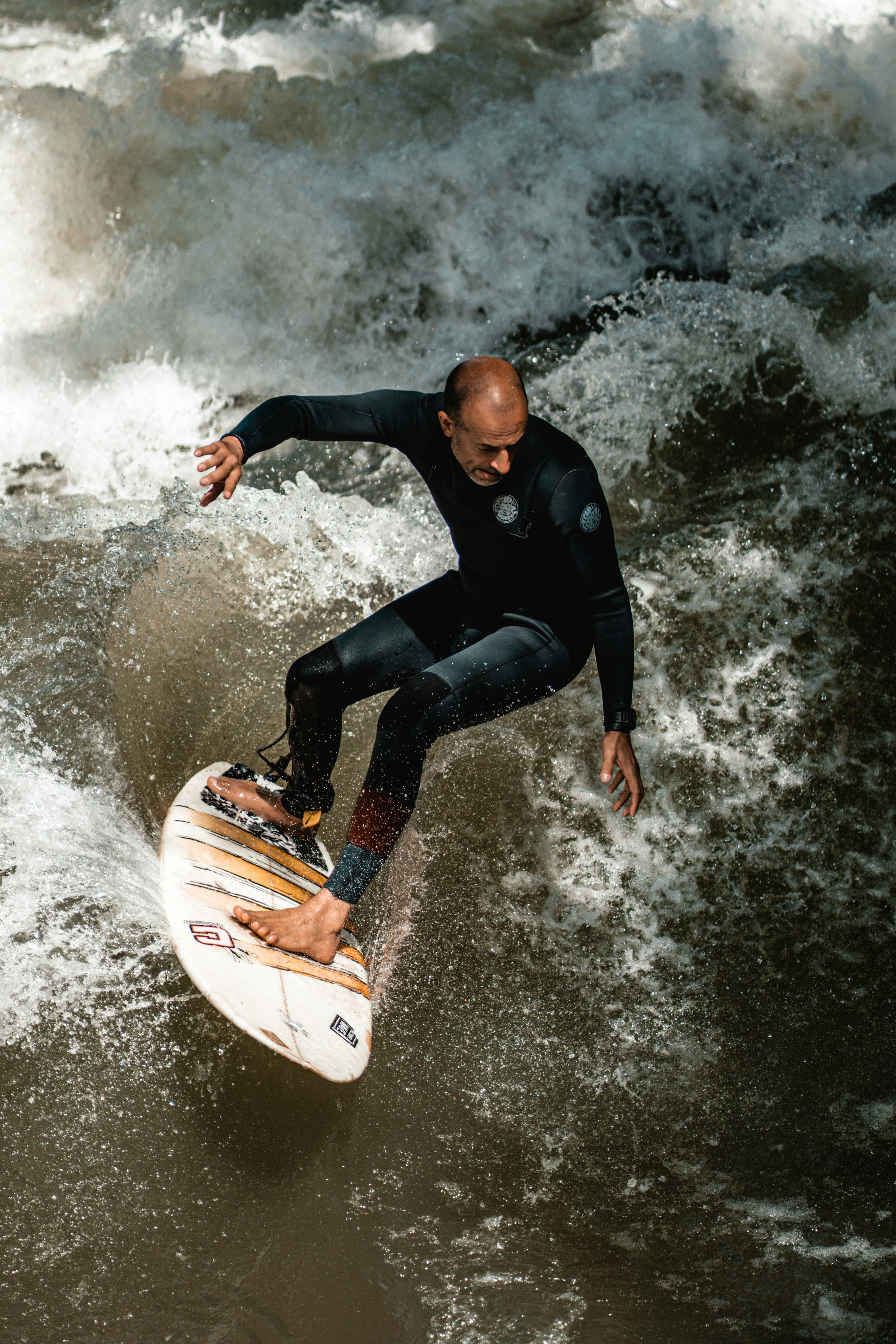 Homme en combinaison noire surfant sur l’eau pendant la journée photo ...