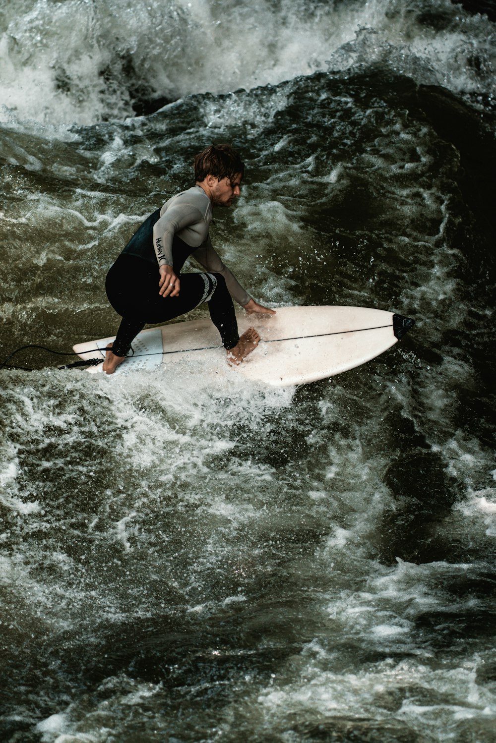 woman in black tank top and black pants surfing on sea waves during daytime