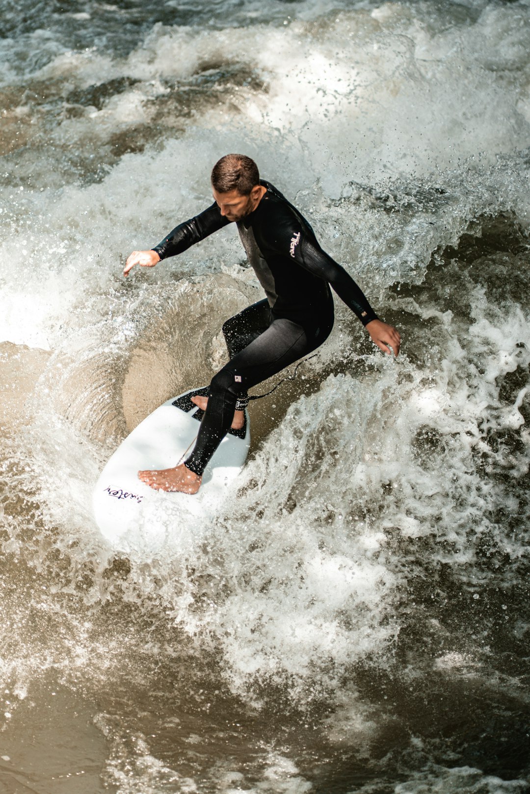 man in black wetsuit surfing on sea waves during daytime