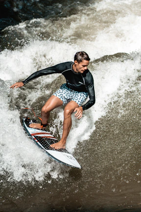 Close-up of a surfer in Alma Souldreams apparel catching a wave with intense focus.