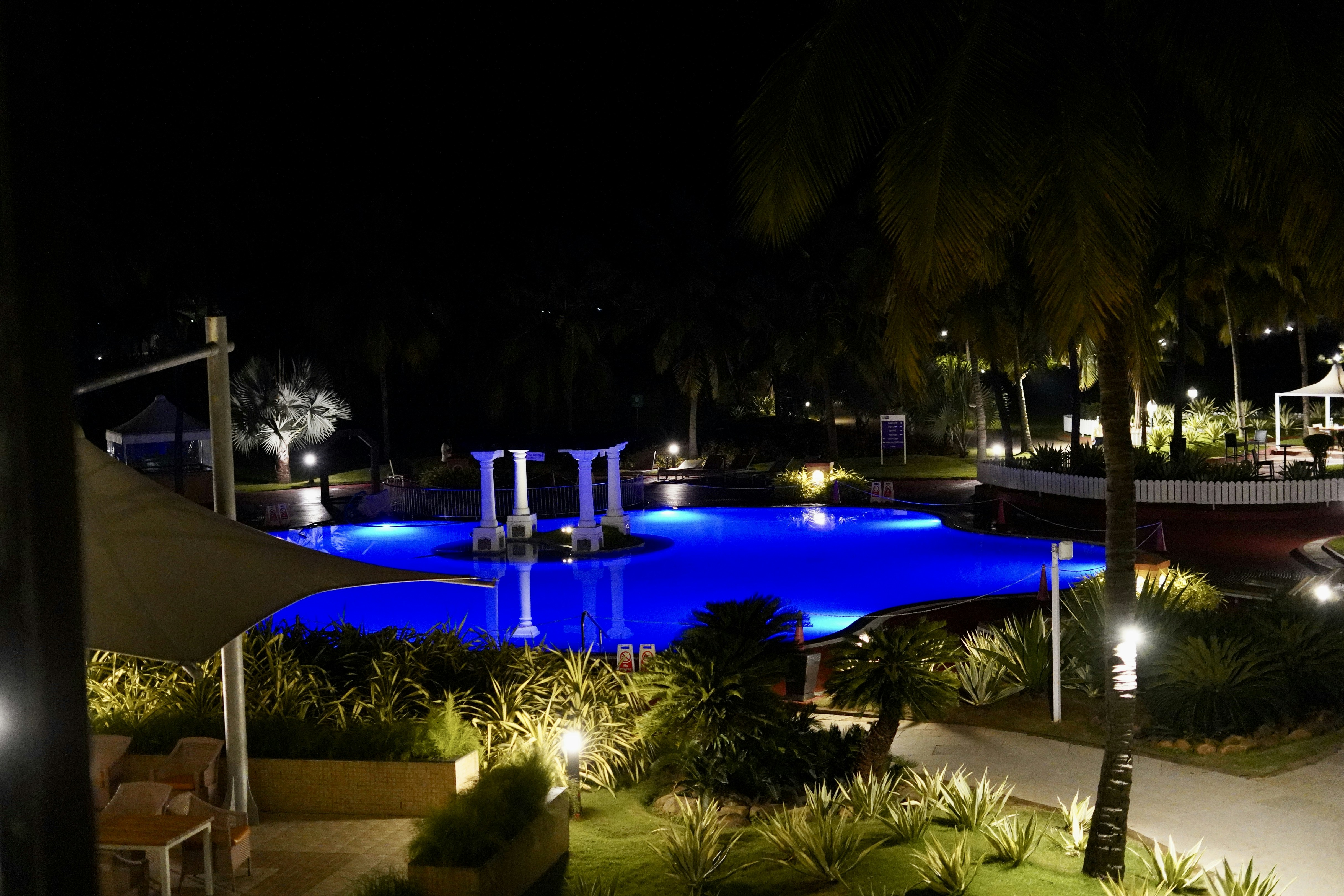 Luxury hotel pool area with neon accent lighting in soft blue and white glow