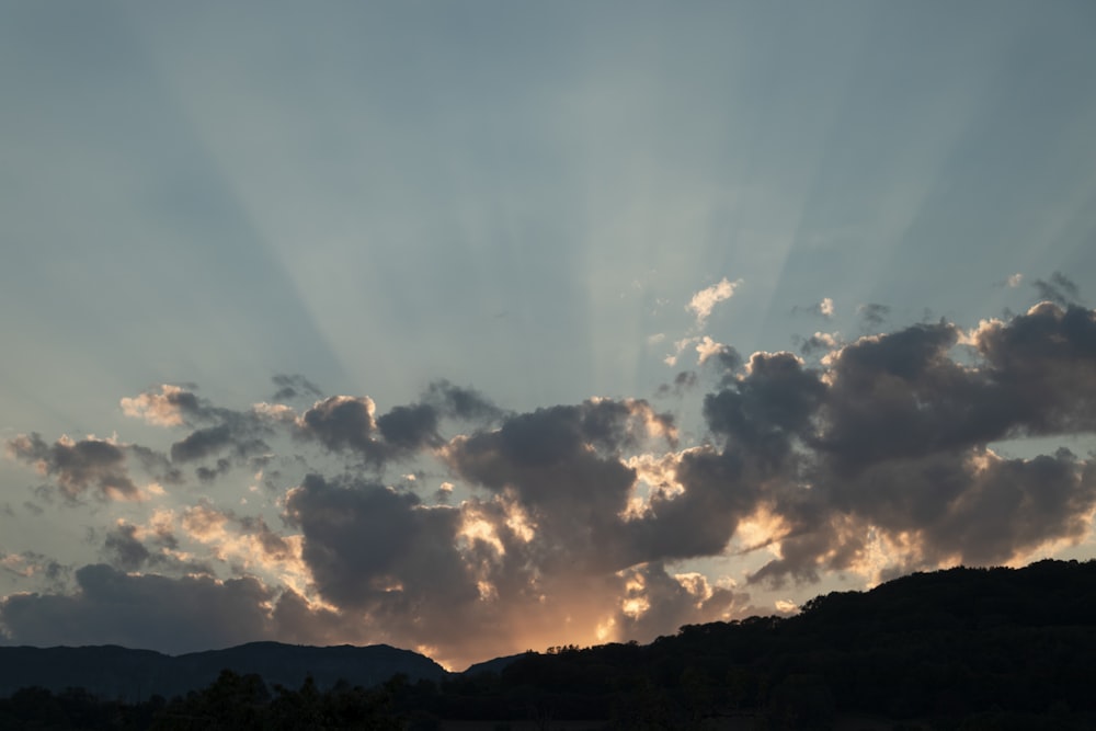 silhouette of mountain under cloudy sky during daytime