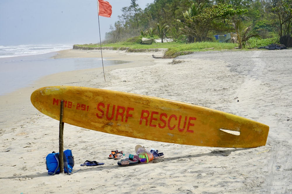 yellow surfboard on white sand beach during daytime