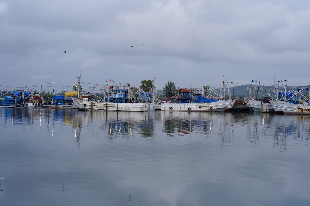 white and blue boat on sea under white sky during daytime