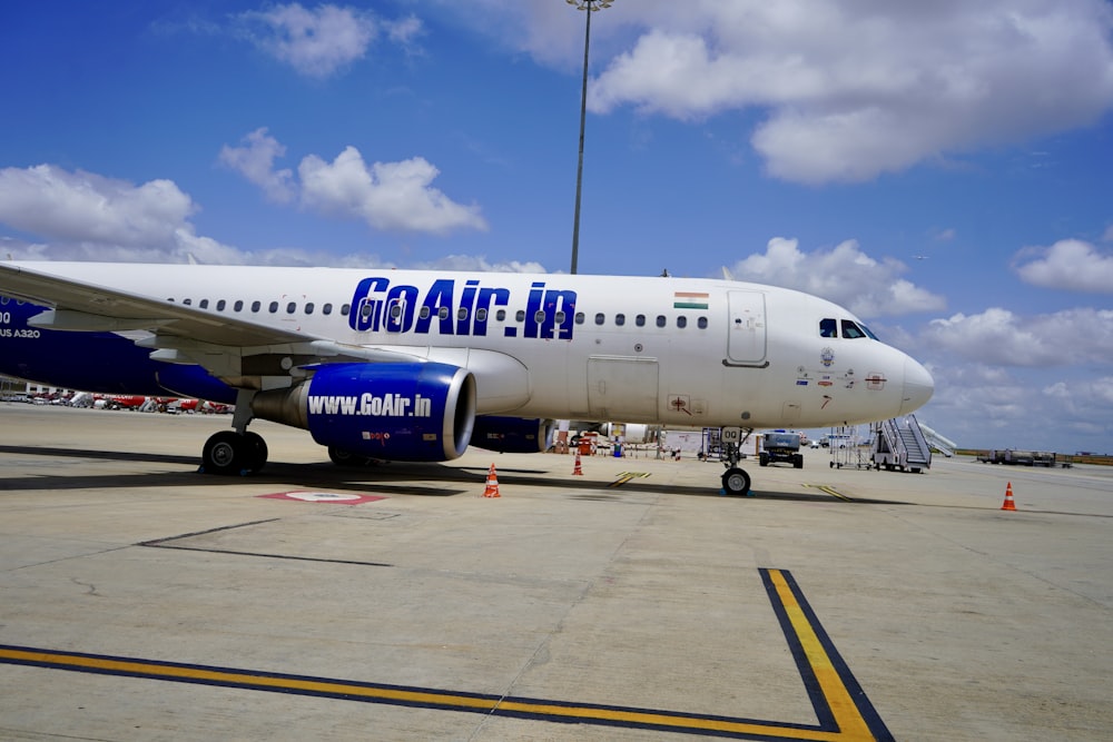 aereo passeggeri bianco e blu sull'aeroporto durante il giorno