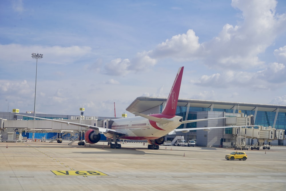 weißes und rotes Flugzeug tagsüber am Flughafen