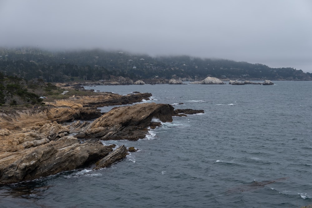 brown rock formation beside body of water during daytime