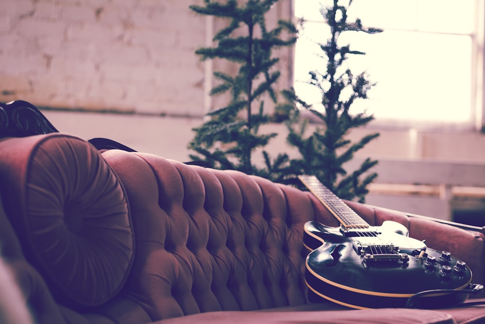 black and white stratocaster electric guitar on brown couch