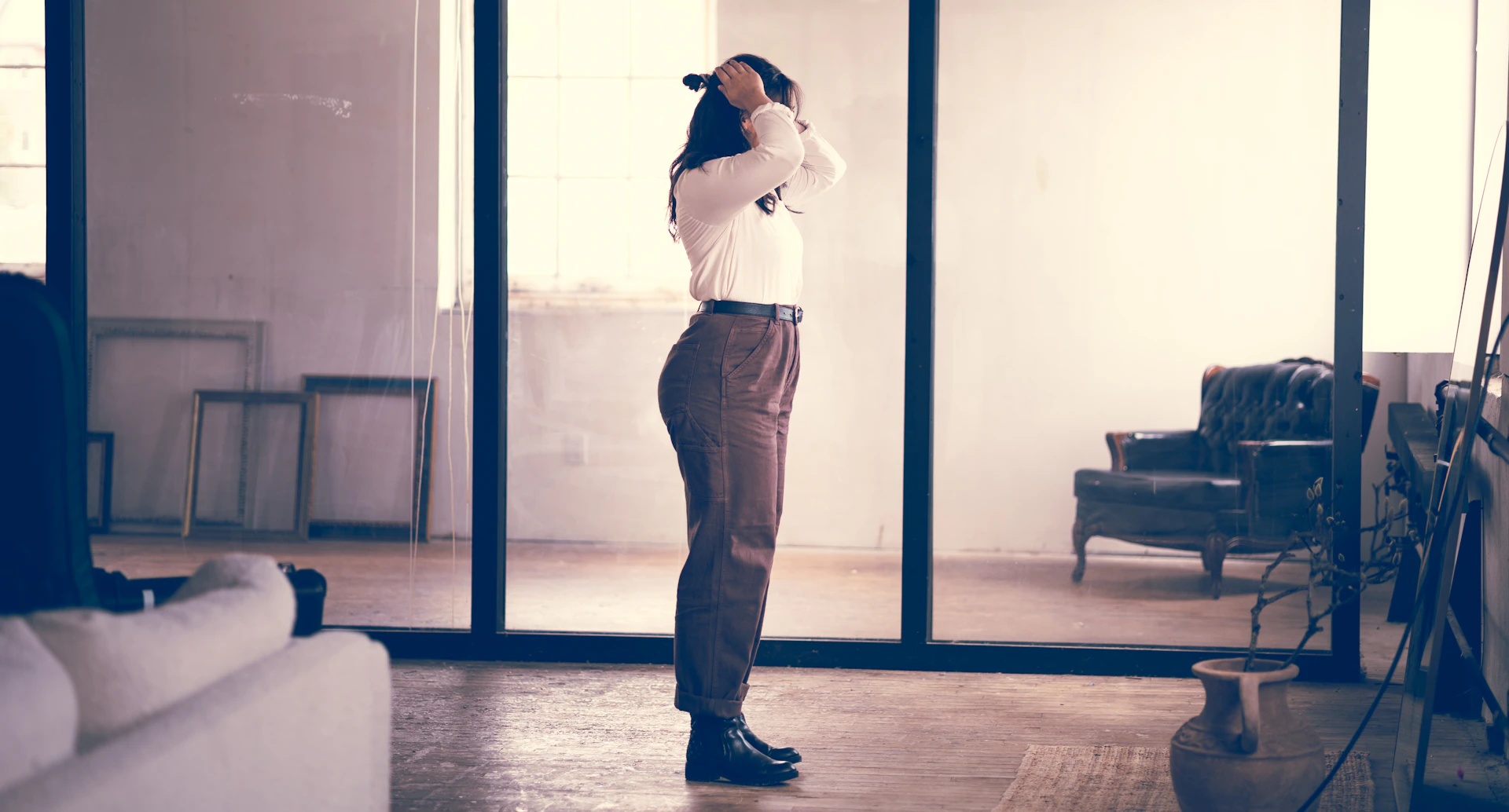 man in white dress shirt and gray pants standing beside blue wooden door