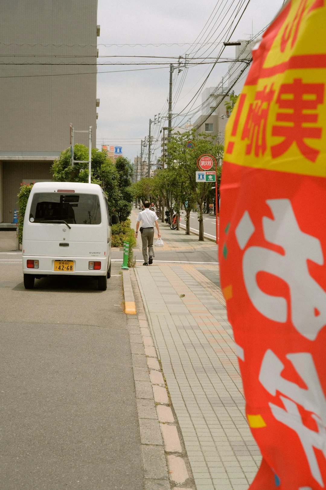 man in white long sleeve shirt and black pants walking on sidewalk during daytime