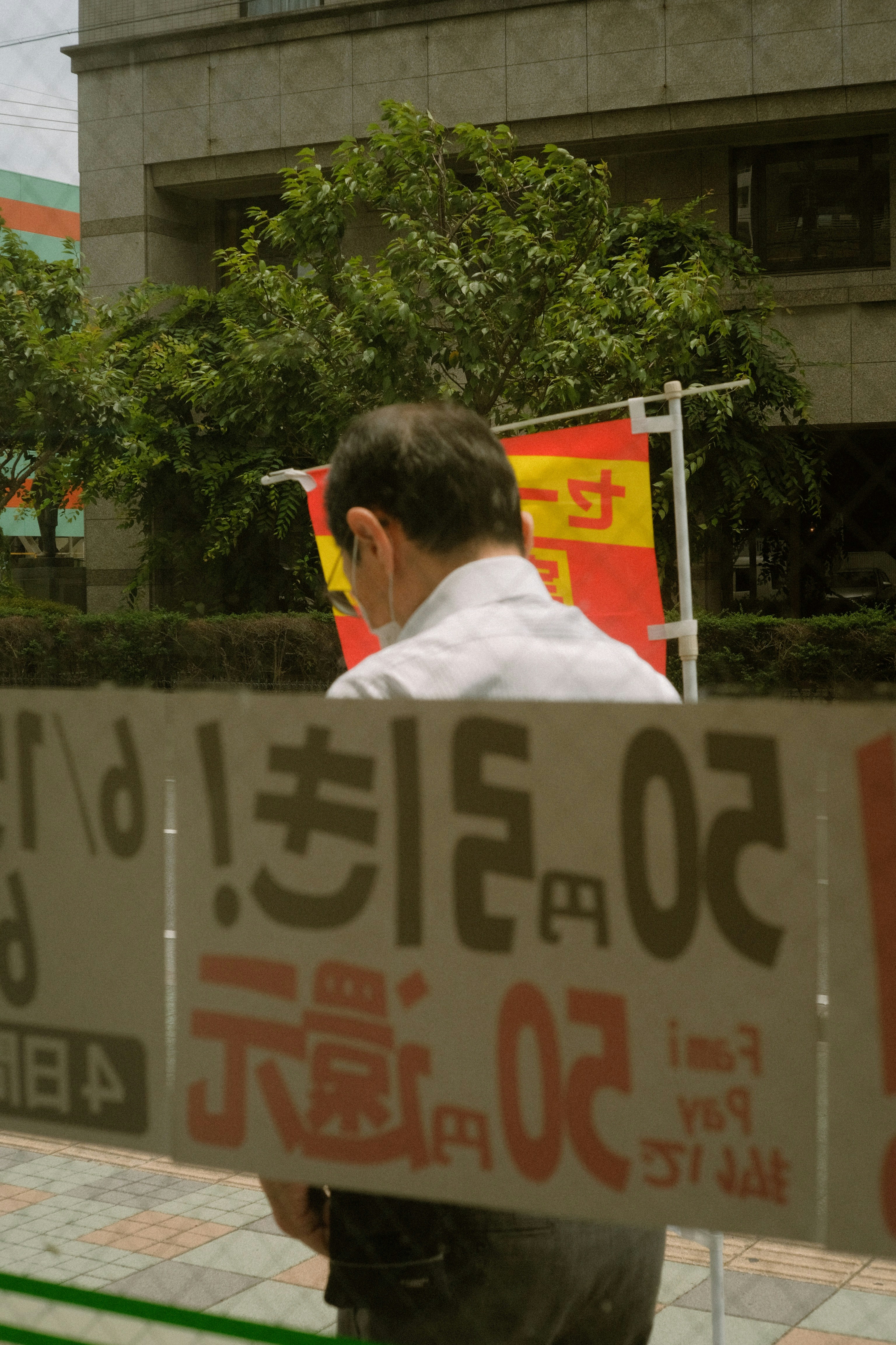 man in white dress shirt standing near white and red stop sign