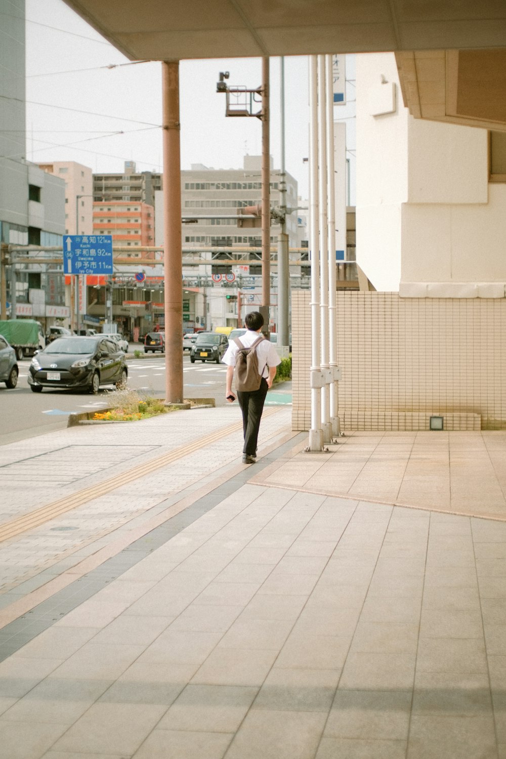 man in white dress shirt and black pants walking on sidewalk during daytime