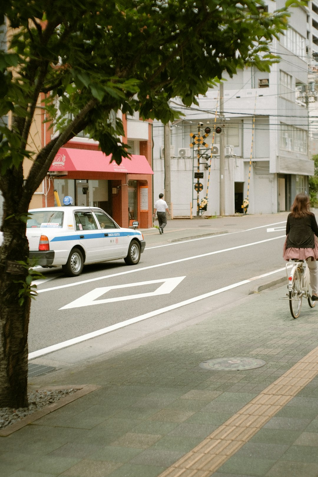 woman in pink jacket riding bicycle on road during daytime