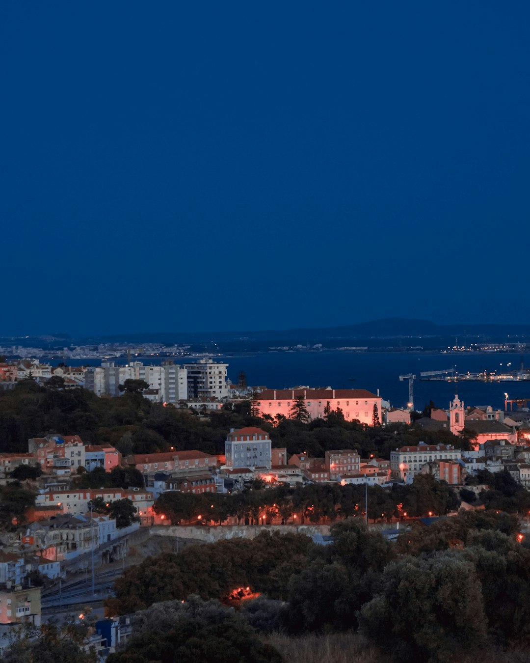 city skyline under blue sky during night time